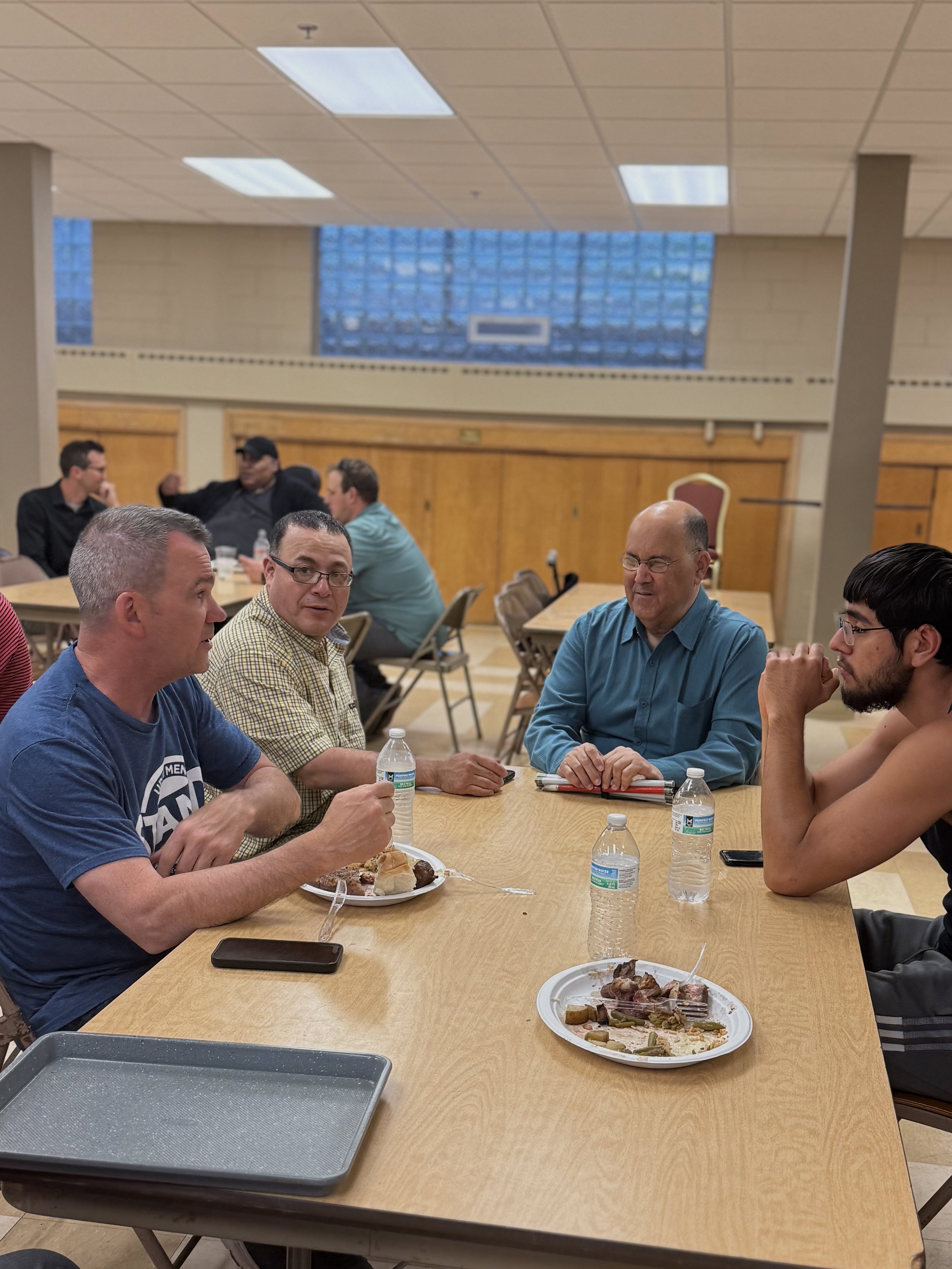 Men playing cornhole wearing UPCI Stand shirts at Wisconsin Men's Ministry outdoor event